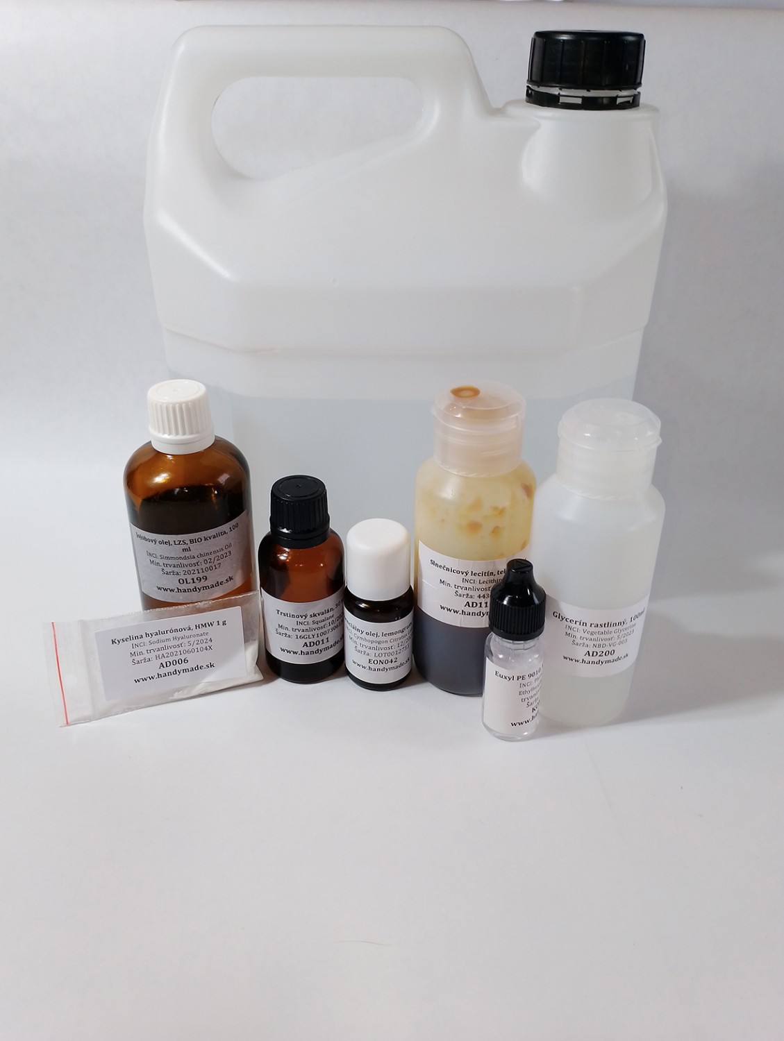 Suroviny na výrobu pleťovéo gélu s kyselinou hyalurónovou vo fľaškách, sáčkoch a nádobkách na bielom pozadí.